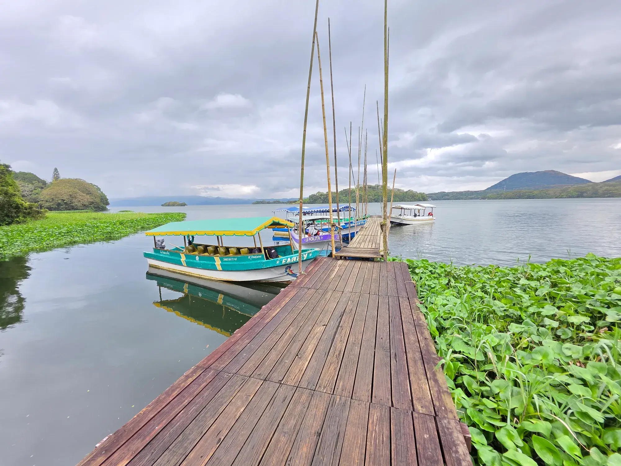 Embarcadero de madera con lanchas sobre el Lago de Catemaco y los cerros al fondo, en Los Tuxtlas, Veracruz
