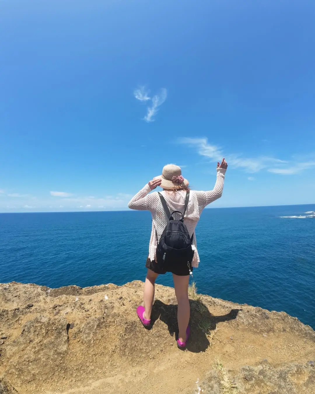 Viajera contemplando el mar azul desde un acantilado de la costa de Los Tuxtlas