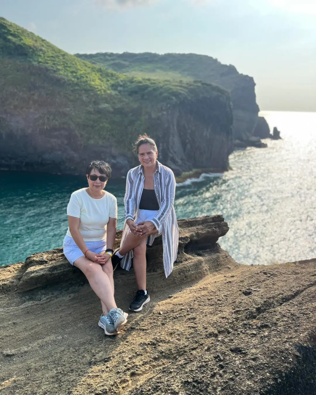 Dos viajeras en las rocas frente a los acantilados y el mar de la costa de Los Tuxtlas