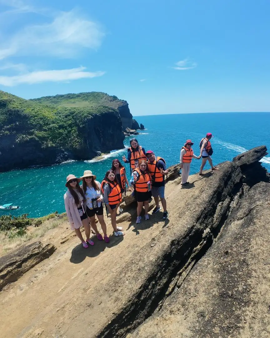 Grupo de viajeros con chaleco en un mirador rocoso sobre el mar turquesa de la costa de Los Tuxtlas con BoteTur
