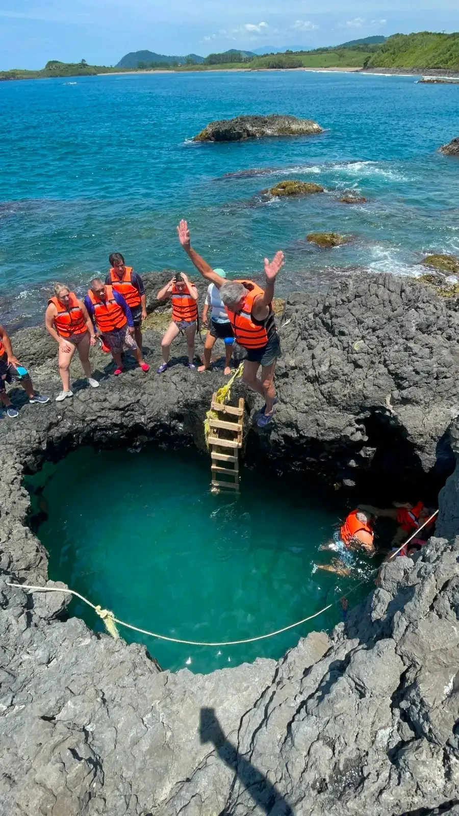 Visitante a punto de aventarse un clavado a la poza de roca volcánica de Playa Ermita, en la costa de Los Tuxtlas, Veracruz