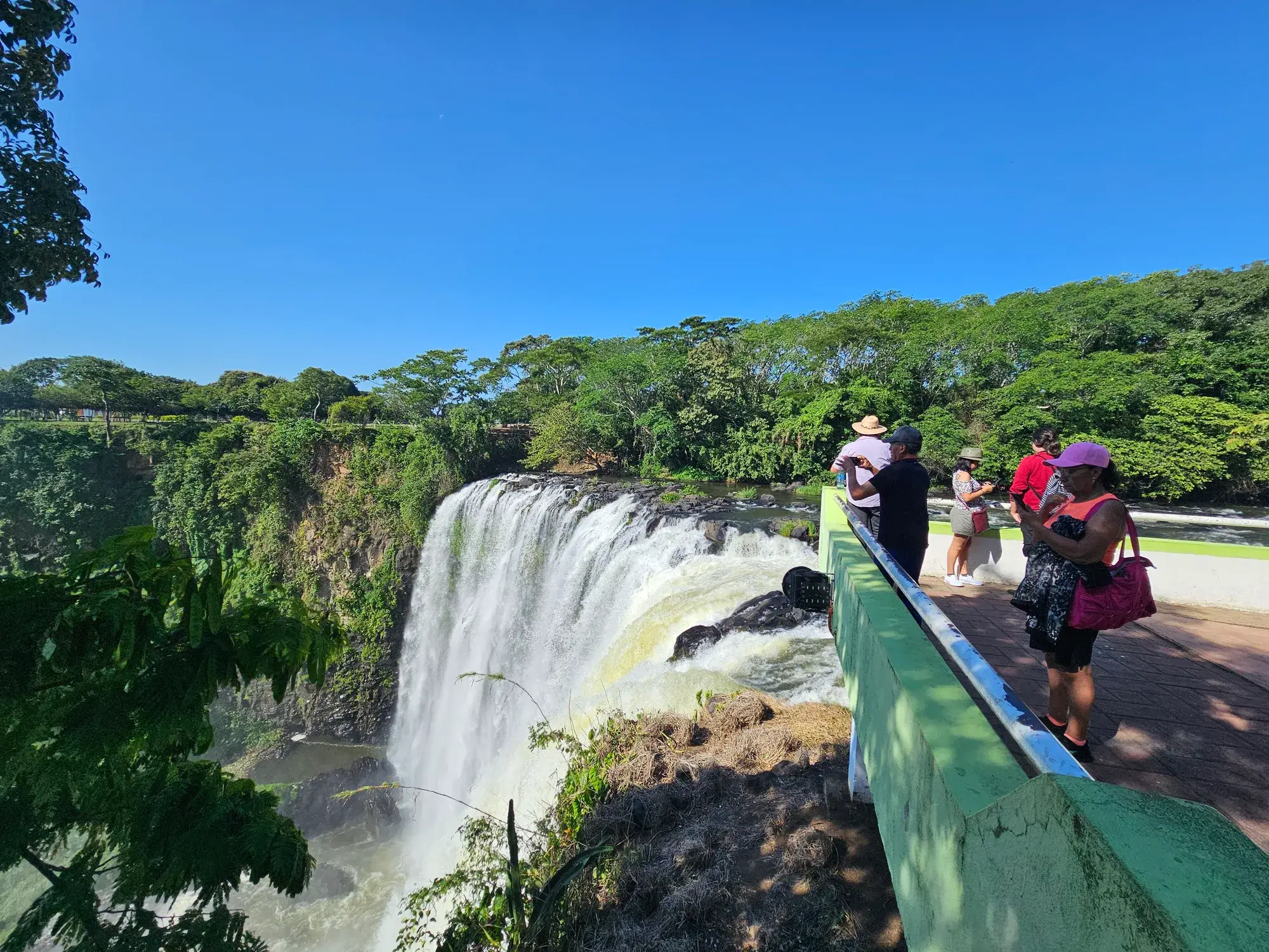 Visitantes en el mirador de arriba del Salto de Eyipantla tomando fotos de la caída de agua, en Los Tuxtlas, Veracruz