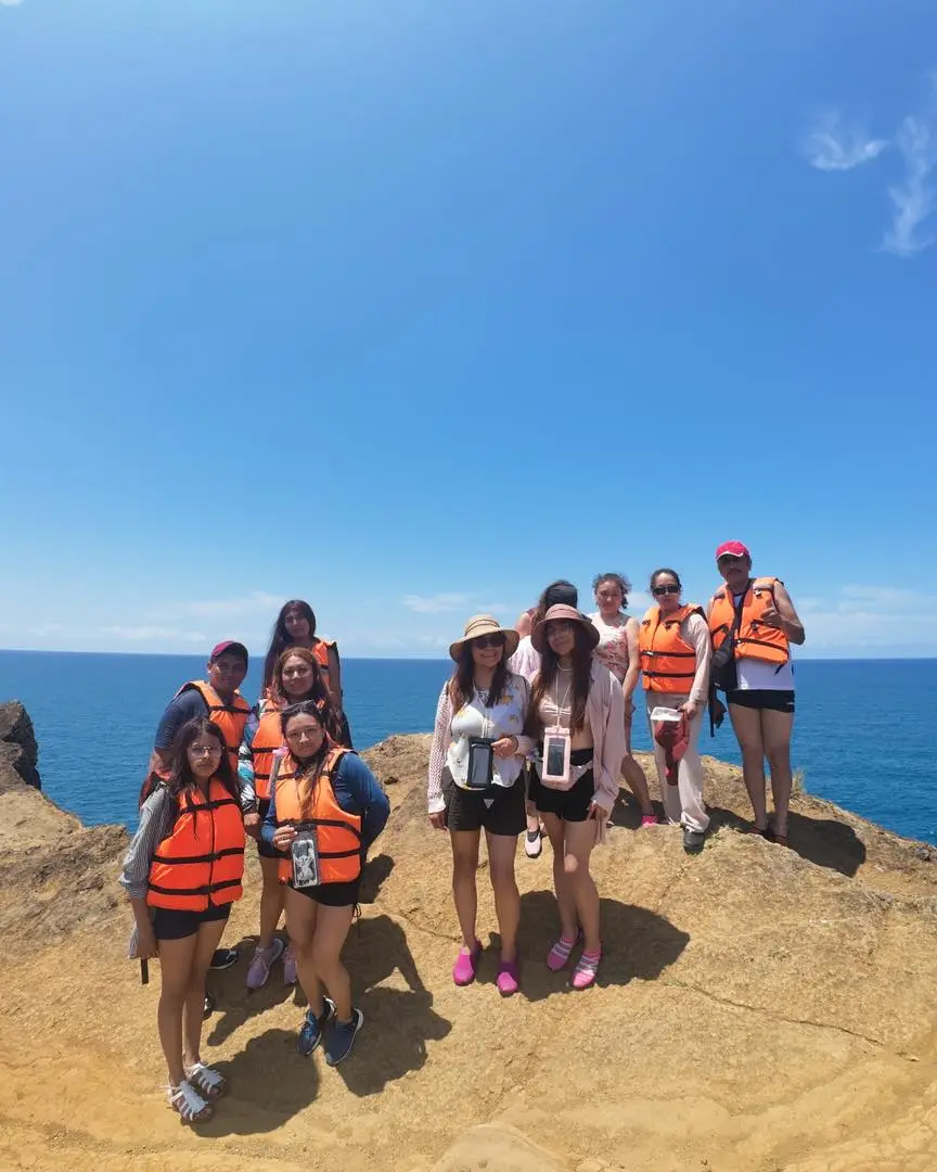 Grupo de viajeros con su guía de BoteTur en un mirador sobre el mar