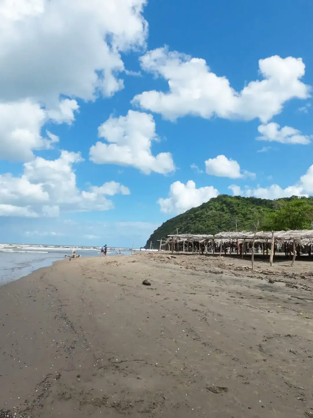 Playa de arena oscura de Montepío con enramadas de palma y el mar rompiendo, en la costa de Los Tuxtlas, Veracruz