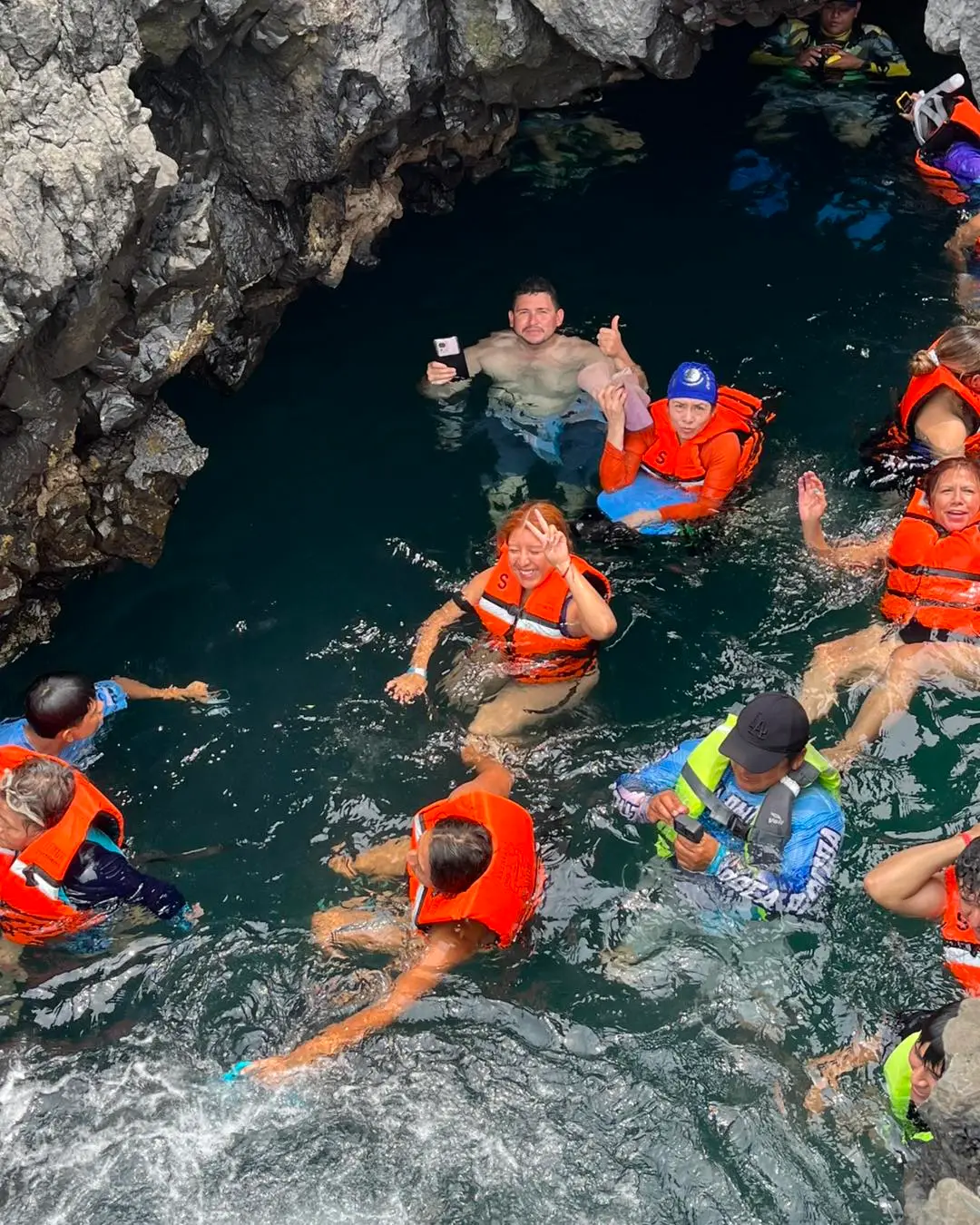 Grupo de viajeros nadando con chaleco entre las rocas de la costa de Los Tuxtlas
