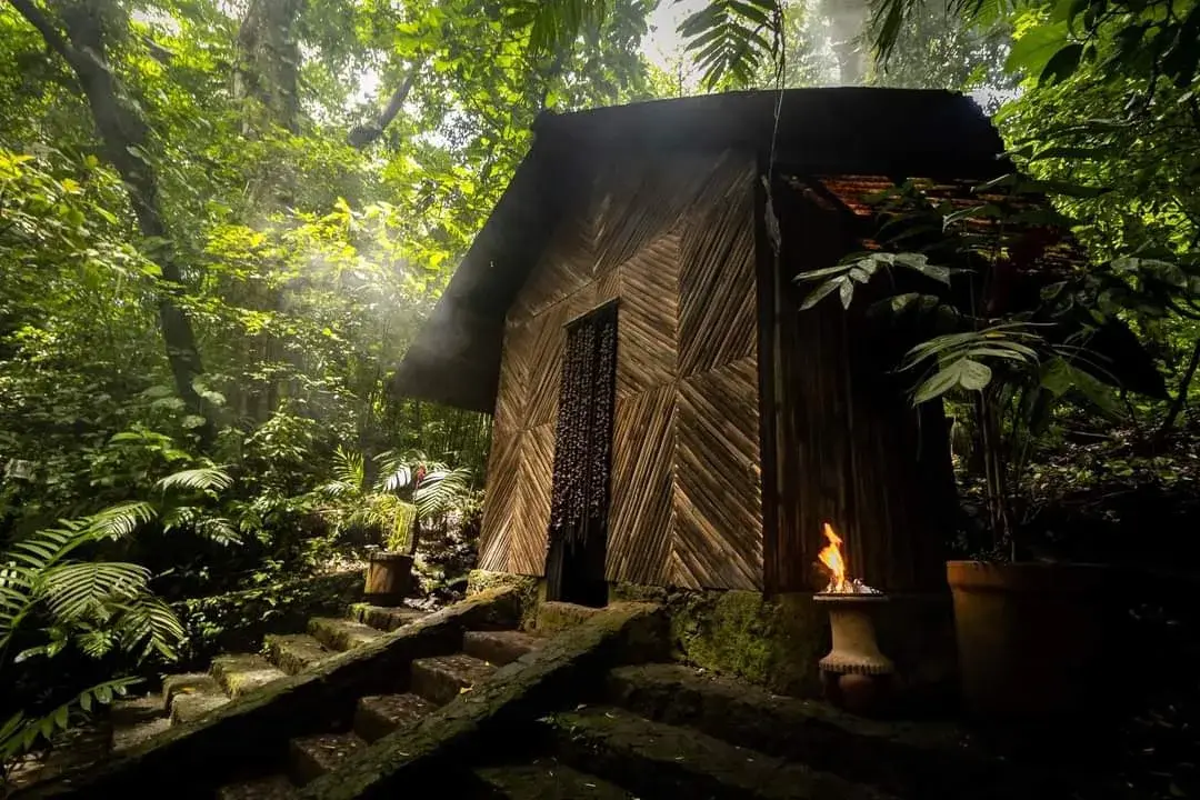 Temazcal de madera entre la selva iluminada por rayos de sol en la reserva de Nanciyaga, Catemaco, Veracruz