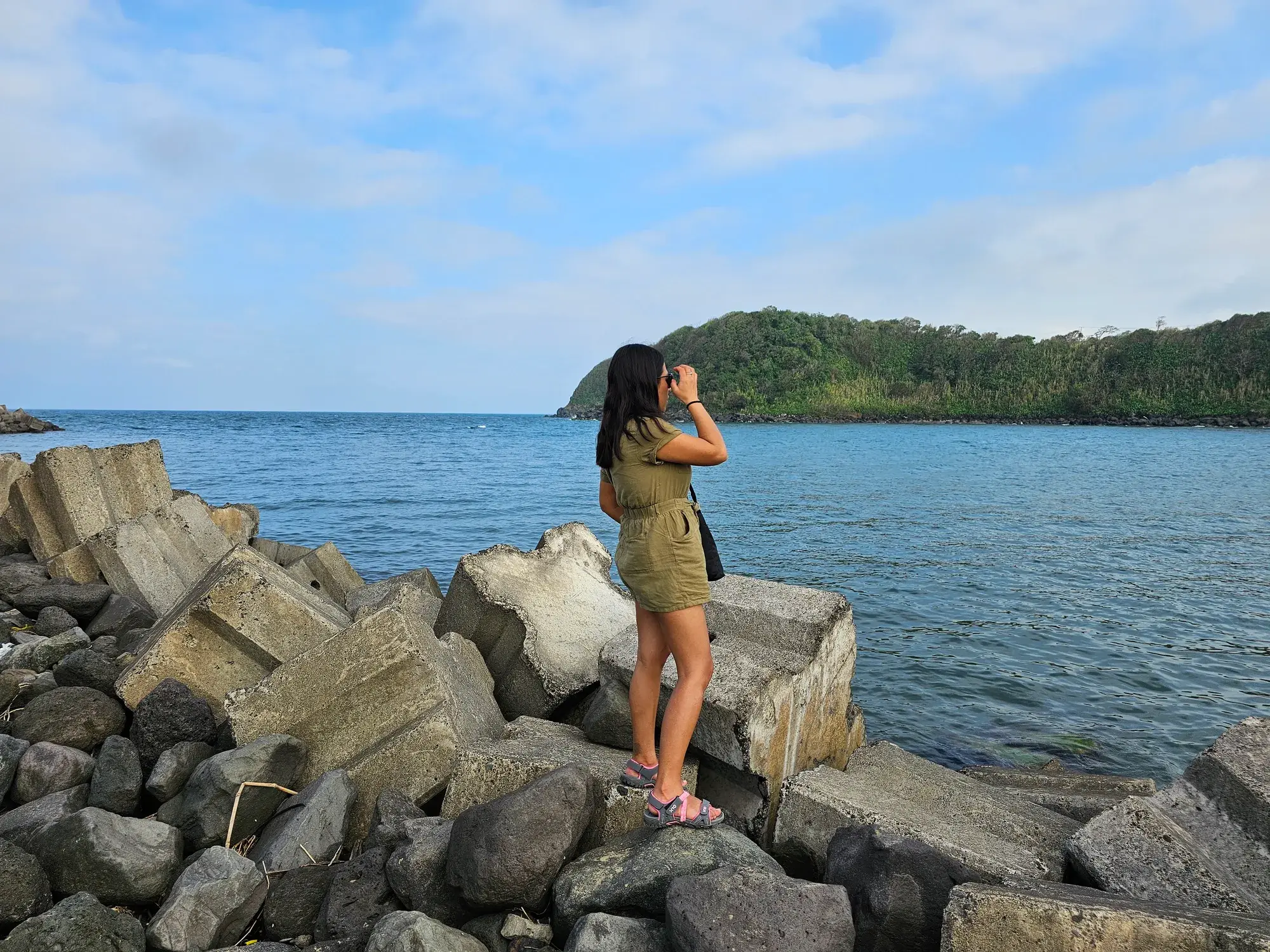 Viajera sobre las rocas de La Barra de Sontecomapan mirando el mar donde la laguna se une con el Golfo de México, en Los Tuxtlas