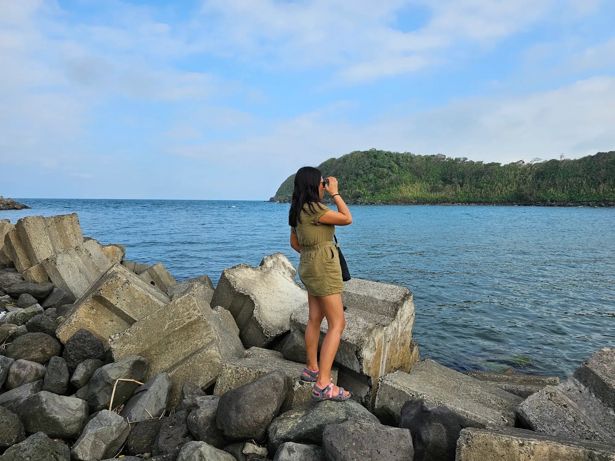 Viajera sobre las rocas de La Barra de Sontecomapan mirando el mar donde la laguna se une con el Golfo de México, en Los Tuxtlas